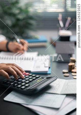Finance bank tax expense accounting budget money businessman home for Business expense analysis saving use Financial calculate accountant close up calculator with graph chart hand write office desk 126321025