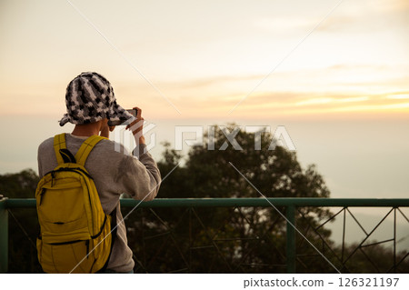 Man traveler with camera backpack hiking outdoor travel lifestyle and adventure concept. cap backpack and join of tourist for green mountain tour, beauty of nature and expansive sky people of tourism 126321197