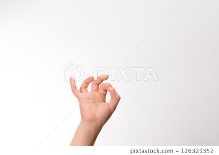 Hand gesture against a white background. A person's hand forms an 'OK' sign, a universal symbol of approval and agreement. Hand gesture against a white background. A person's hand forms an 'OK' sign, a universal symbol of approval and agreement. 126321352