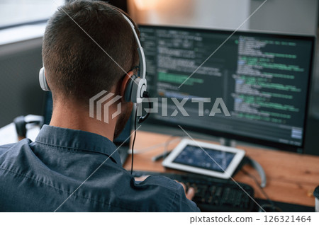 Software developer is writing code. Man in formal clothes is working in the modern office. Using computer 126321464