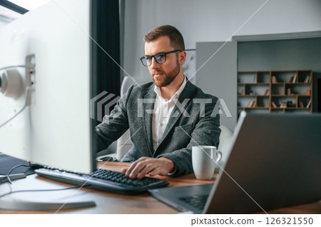 Businessman in suit is in the office with computer 126321550