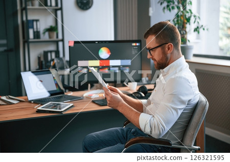 Graphic designer is sitting. Man in formal clothes is working in the modern office. Using computer 126321595
