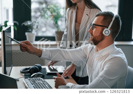 Analyzing information that is on the screen. Two employees are working together in the modern office 126321813