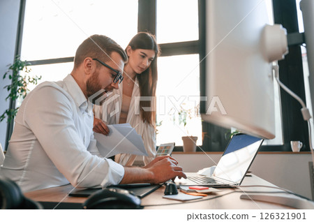 Side view. Paper work. Two employees are together in the modern office 126321901