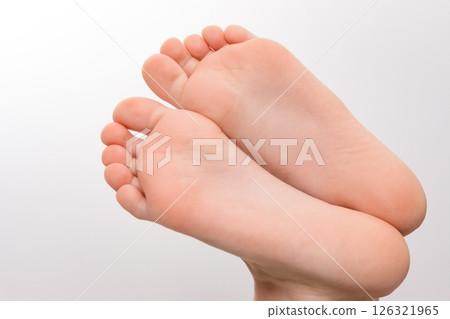 Close-up of two small, clean feet soles against a white background. 126321965