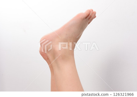 Close-up of a human foot and ankle against a white background. 126321966