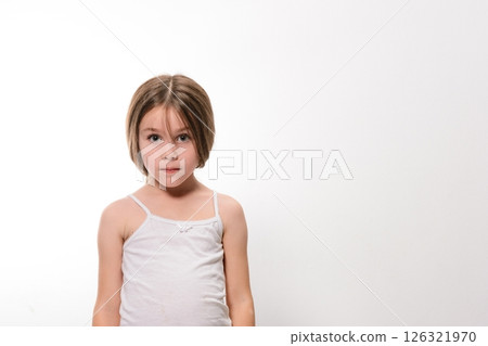 Young girl in a white tank top against a white background. A simple portrait. 126321970