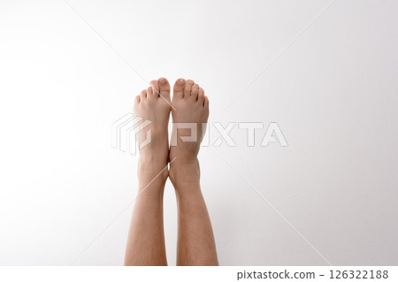 Bare feet raised against a white background. Simple, clean image perfect for health, beauty, or wellness concepts. Bare feet raised against a white background. Simple, clean image perfect for health, beauty, or wellness concepts. 126322188