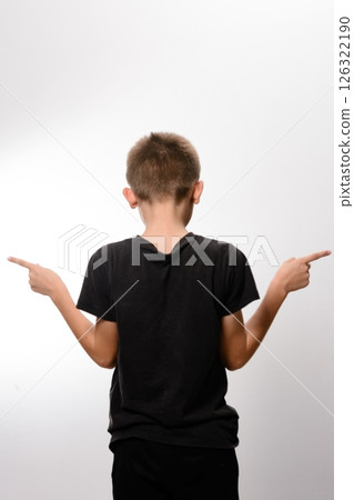 Boy pointing in opposite directions, indecisive gesture. 126322190
