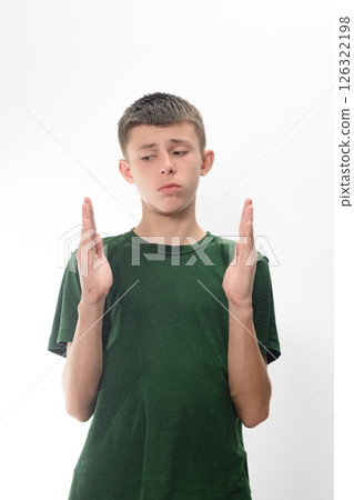 Teenage boy looking thoughtful, hands gesturing, against a white background. 126322198