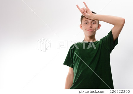 Teenager playfully making a silly face with hand gesture. 126322200