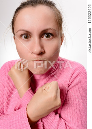 Woman with clenched fists and a determined expression. 126322493