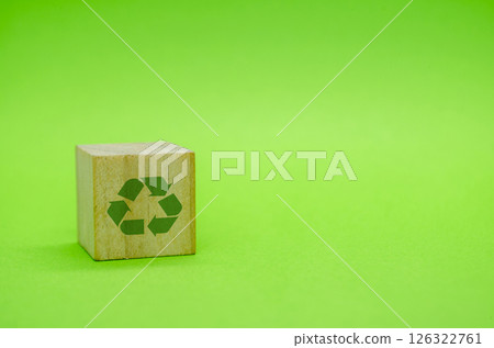 Recycle symbol with wooden blocks on green background. Promoting reuse, reduce, and recycle for sustainability Recycle symbol with wooden blocks on green background. Promoting reuse, reduce, and recycle for sustainability 126322761