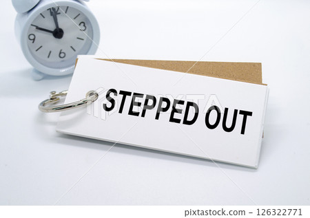 Stepped Out text on white notepad with alarm clock on white background. Away from office concept 126322771