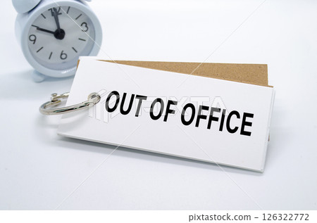 Out Of Office text on white notepad with alarm clock on white background. Away from office concept Out Of Office text on white notepad with alarm clock on white background. Away from office concept 126322772