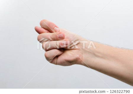 Hand making a fig sign gesture against a plain background. Hand making a fig sign gesture against a plain background. 126322790