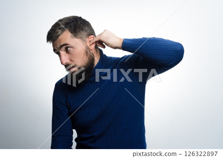 Man with beard cleans his ear 126322897