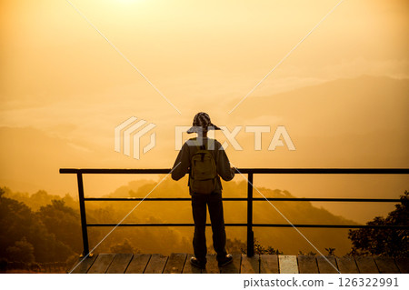 Man traveler with camera backpack hiking outdoor travel lifestyle and adventure concept. cap backpack and join of tourist for green mountain tour, beauty of nature and expansive sky people of tourism Man traveler with camera backpack hiking outdoor travel lifestyle and adventure concept. cap backpack and join of tourist for green mountain tour, beauty of nature and expansive sky people of tourism 126322991