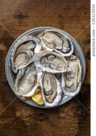 Fresh raw oysters on ice, overhead flat lay shot Fresh raw oysters on ice, overhead flat lay shot 126323050