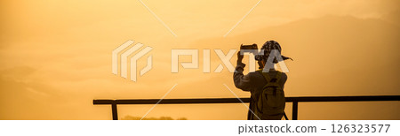 Man traveler with backpack hiking outdoor travel lifestyle and adventure concept. join of tourist for green mountain tour beauty of nature and expansive sky people of tourism. banner with copy space 126323577