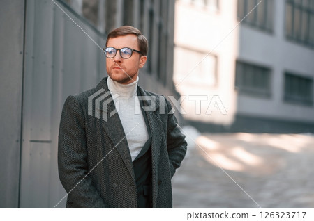 Portrait of handsome man that is in formal clothes is outdoor near the business building Portrait of handsome man that is in formal clothes is outdoor near the business building 126323717