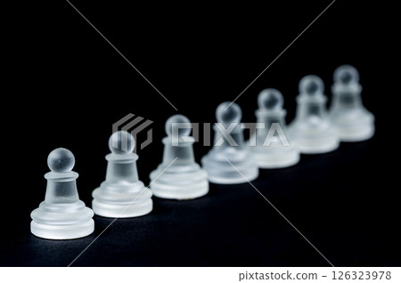 opaque glass chess pawn row on black background, selective focus, closeup 126323978