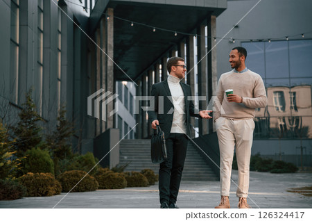 Businessman in formal clothes is with black man outdoors in the city 126324417