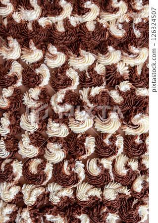 Chocolate and vanilla swirl cake frosting. Background with selective focus and copy space Chocolate and vanilla swirl cake frosting. Background with selective focus and copy space 126324507