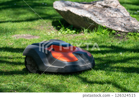 Autonomous Lawn Mower on Green Grass in a Sunny Park During the Day 126324515
