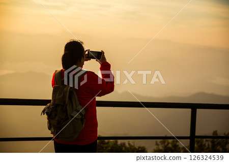 Woman traveler with backpack hiking outdoor travel lifestyle and adventure concept. cap backpack and join of tourist for green mountain tour, beauty of nature and expansive sky people of tourism Woman traveler with backpack hiking outdoor travel lifestyle and adventure concept. cap backpack and join of tourist for green mountain tour, beauty of nature and expansive sky people of tourism 126324539