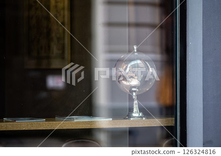 glass globe on table, view through window with street reflections, copy space glass globe on table, view through window with street reflections, copy space 126324816