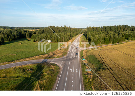Aerial View of a Rural Road Intersection With Trees and Fields on a Sunny Day 126325826