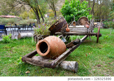 Vintage Wooden Cart Displaying Clay Pots and Garden Decor Under a Sunny Sky Vintage Wooden Cart Displaying Clay Pots and Garden Decor Under a Sunny Sky 126325890
