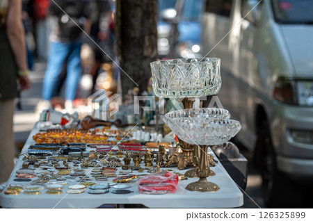 Open-Air Market Stall Displaying Vintage Jewelry And Antique Items During Sunny Day Open-Air Market Stall Displaying Vintage Jewelry And Antique Items During Sunny Day 126325899