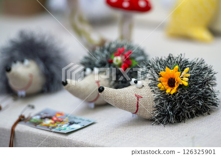 Adorable Handmade Hedgehog Decorations With Flowers in a Craft Fair Setting Adorable Handmade Hedgehog Decorations With Flowers in a Craft Fair Setting 126325901