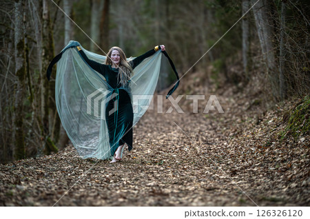 Woman dancing in a forest path. Shallow depth of feld 126326120