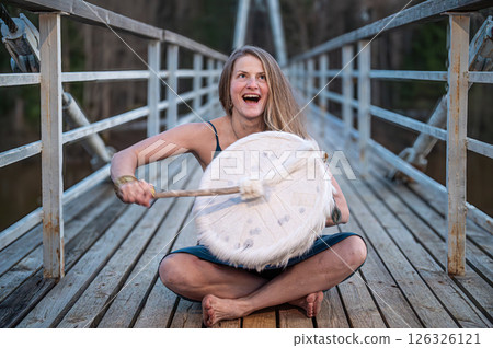 Woman playing a drum on a bridge. Shallow depth of feld 126326121