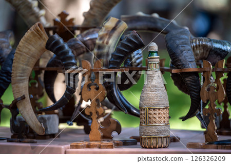 Artisan Display of Intricate Horn Sculptures and Woven Bottle at Outdoor Market Event 126326209