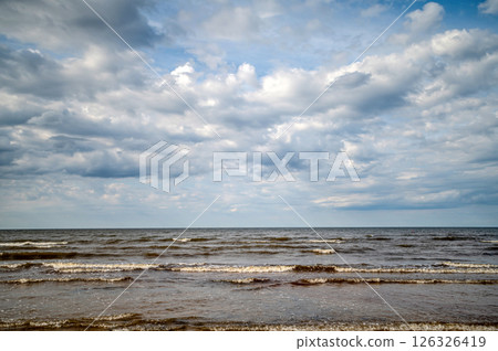 Gentle waves move towards the beach while clouds fill the evening sky. Gentle waves move towards the beach while clouds fill the evening sky. 126326419