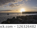 Golden sunset view of Playa de San Juan bay with protected sand beach and small harbor. Playa de San Juan is a small fishing village on the south west of Tenerife island. 126326482