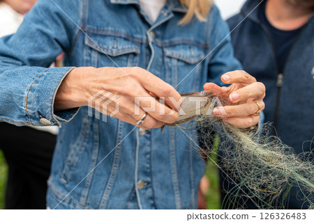 A person demonstrating the process of handling fishing line while outdoors on a sunny day 126326483