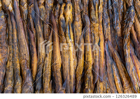 Various dried fish arranged neatly on display, showcasing their texture and color. 126326489