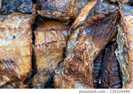 Close-up view of dried fish with rich textures and warm tones, highlighting their natural hues. 126326490