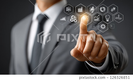Businessman in suit interacting with futuristic virtual interface using gesture-based technology for data analysis and innovation 126326851