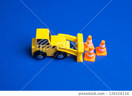 A yellow bulldozer moves traffic cones. The concept of establishing or removing restrictions. Implementing new rules. Construction zones. Policy adjustments, and public safety measures. 126328118