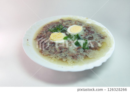 aspic with meat, eggs and fresh parsley, made with thick and rich nutritious bone broth, frozen in elegant white porcelain plate aspic with meat, eggs and fresh parsley, made with thick and rich nutritious bone broth, frozen in elegant white porcelain plate 126328266