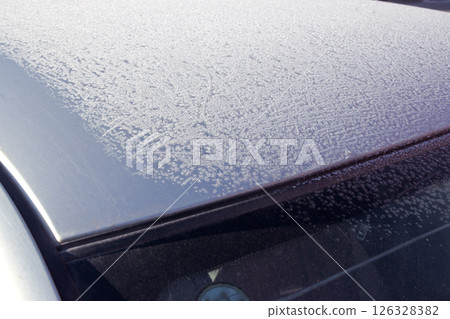 partially covered with frost car roof and windscreen. winter pattern at the sun partially covered with frost car roof and windscreen. winter pattern at the sun 126328382