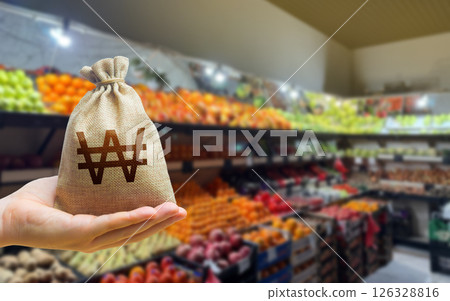 South korean won money bag on the background of a grocery store counter with fresh organic vegetables and fruits. Concept of cost of goods and food products. Grocery set. Import and export 126328816