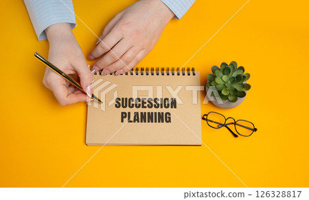 Succession planning. Strategic process of identifying, training, and preparing employees to fill key leadership roles to ensure business continuity and long-term success. A woman writes a notes 126328817