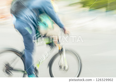 Man in denim suit with child in child seat riding bicycle in city. Dynamic motion blur, modern mobility, urban energy. Healthy lifestyle, leisure concept Man in denim suit with child in child seat riding bicycle in city. Dynamic motion blur, modern mobility, urban energy. Healthy lifestyle, leisure concept 126329902